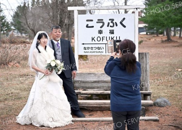 ウエディング衣装で記念撮影する武田夫妻（１２日、帯広市幸福駅で。塩原真撮影）