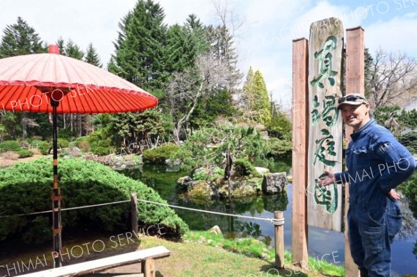 道内では珍しい日本庭園前で来場を呼び掛ける管理責任者の加藤さん（１９日午前１１時半ごろ、真鍋庭園で）