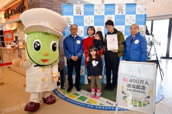 累計来場者数４００万人達成を祝う節目の来場者家族ら（３月８日）