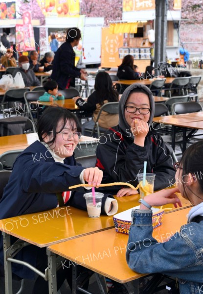 帯広競馬場で開幕した「うまちか」で、談笑しながら食事を楽しむ来場客（３日正午ごろ、塩原真撮影）