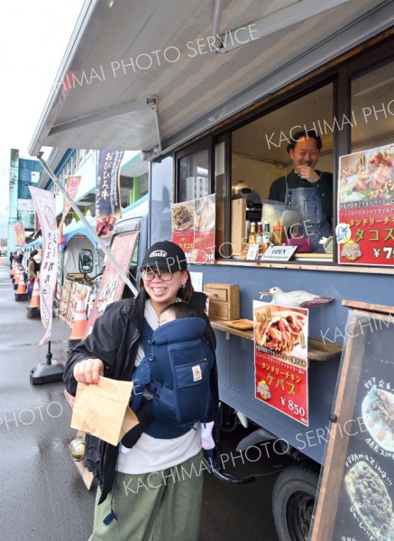 並ぶキッチンカーで買い物をする来場者（３日午前１１時ごろ、塩原真撮影）
