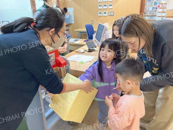 問題に正解し景品を受け取る子どもたち