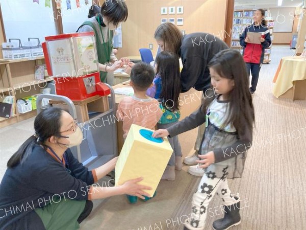 問題に正解し景品を受け取る子どもたち