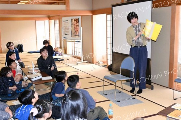絵本「こどもたちは　まっている」に耳を傾ける参加者