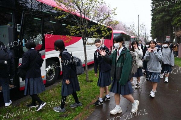 見送りにきた保護者らに手を振りながらバスに乗り込む帯広第四中の生徒（７日午前７時半ごろ、須貝拓也撮影）