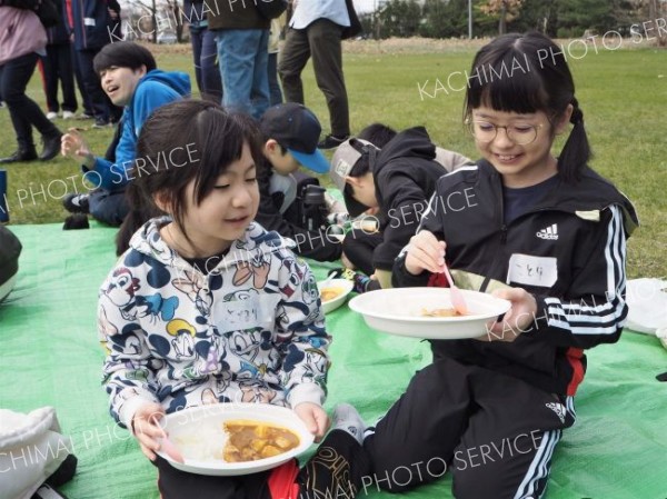 清掃後、ボランティアが振る舞ったカレーを食べる子どもたち