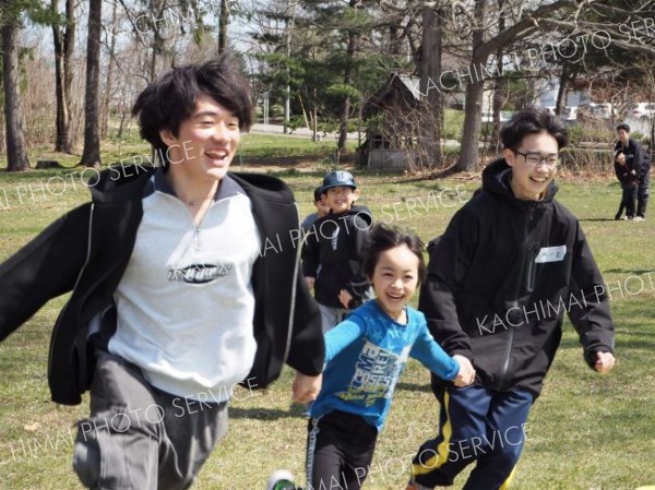 ボランティアの高校生と遊ぶ子どもたち
