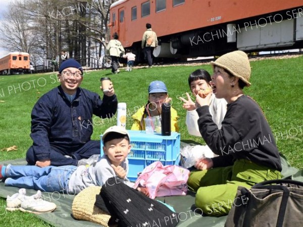 <strong>＜幸福駅で一服＞</strong><br>青空の下でピクニック気分―。連休イベントではキッチンカーや飲食の出店も数多く出店。芝生にレジャーシートを広げ味わう家族連れの姿も見られた（５日、市内の旧幸福駅）