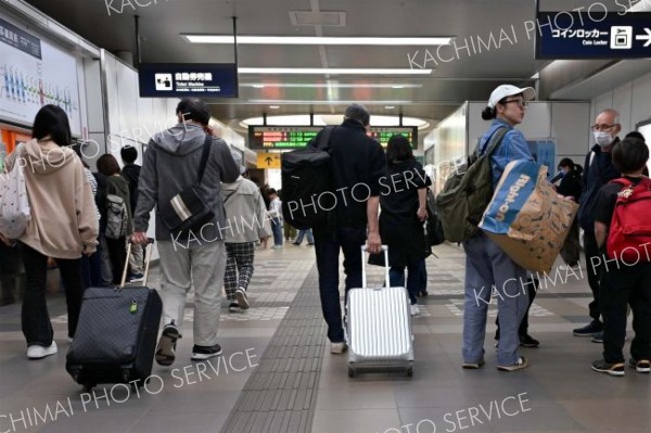 <strong>＜Ｕターン＞</strong><br>楽しかった連休も終わり、家路へ。交通機関を訪れた人の手には、思い出とお土産の詰った大きな荷物（６日、ＪＲ帯広駅）