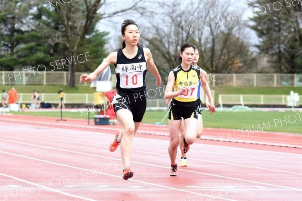 【中学３年女子１００メートル６組】途中、横風にあおられながらも１３秒３５で総合１位となった石川栞（左、緑南）