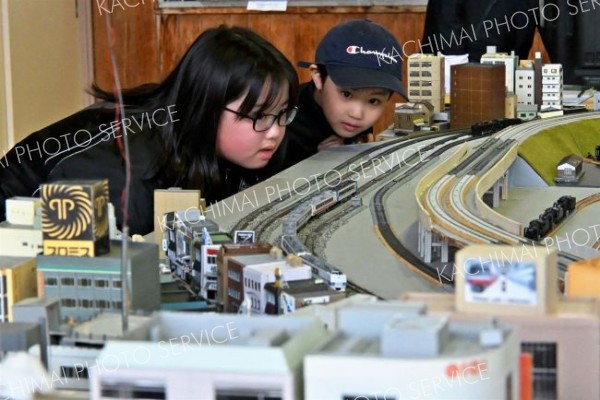 巨大ジオラマの中を本物さながらの迫力で走行するＮゲージの鉄道模型に見入る子どもら