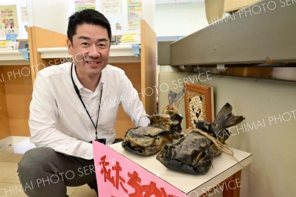 展示中のサケの皮靴と春木支店長