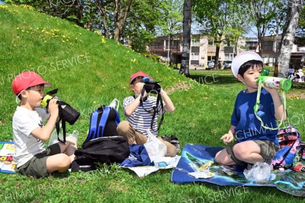 目的地の光南緑地公園に到着し、水分補給をする柏小の１年生（１６日午前９時５０分ごろ、須貝拓也撮影）