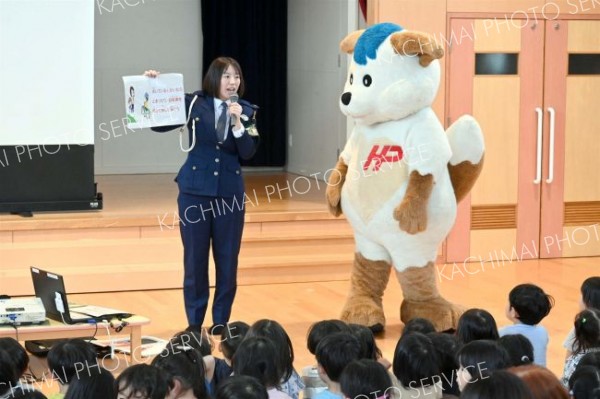 ほくとくんと一緒に、園児らに交通ルールを指導する後藤巡査長（左）