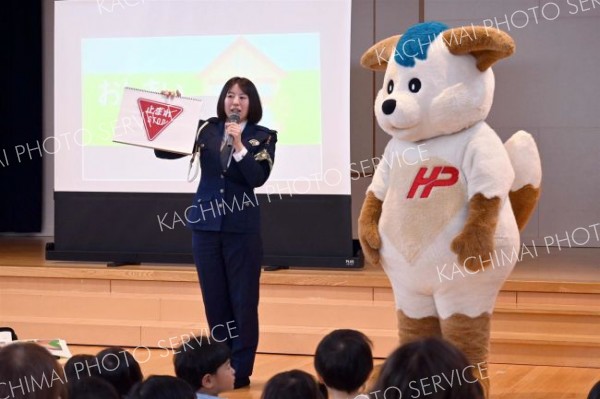 ほくとくんと一緒に、園児らに交通ルールを指導する後藤巡査長（左）
