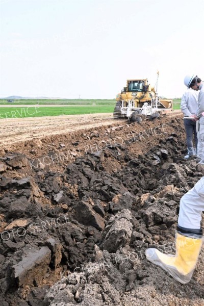 反転プラウで土を掘り起こし、河川掘削土と表土を反転させるトラクター
