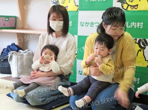 受け取った森の輪に興味を示す乳児