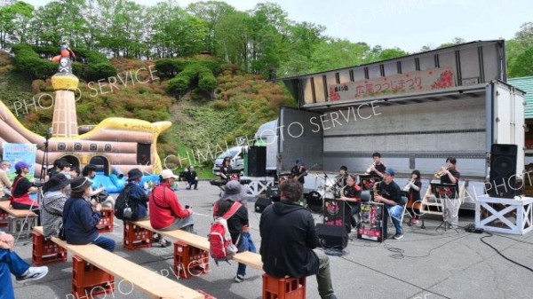 ツツジが赤く色づく会場でイベントなどを楽しむ来場者ら（１８日午前１０時４０分）