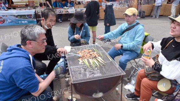 焼き台で食事を楽しむ来場者ら