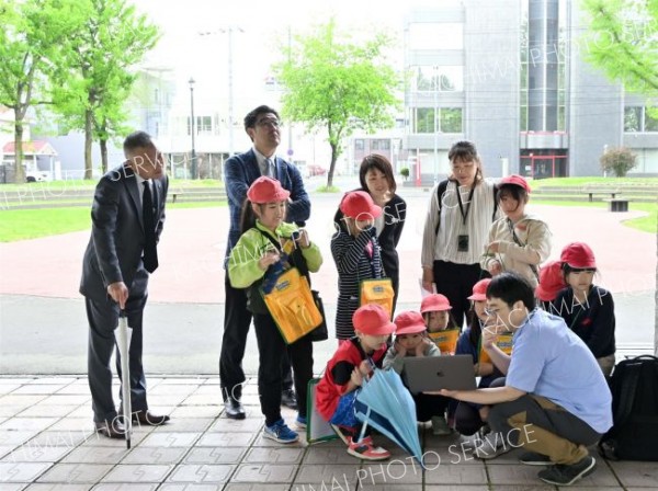 大和田さん（右）の解説に聞き入る児童ら