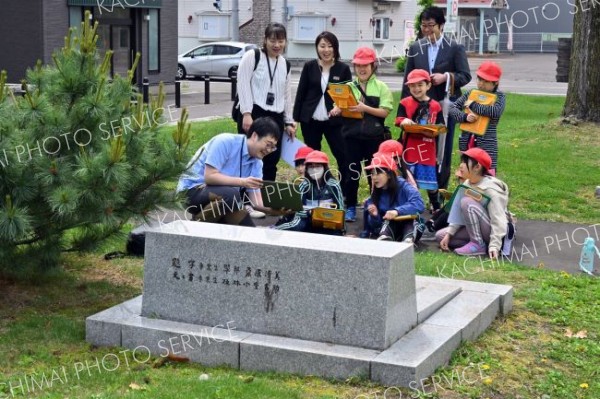 旧帯広小学校跡地（現帯広中央公園）で、大和田学芸員（左手前）の説明を受ける児童ら（金野和彦撮影）