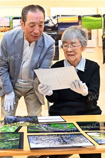 フォトクラブ昴の例会で、同クラブの工藤正志代表（左）から作品のアドバイスを受ける（金野和彦撮影）