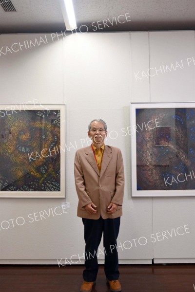 本人の力作の前で来場を呼び掛ける