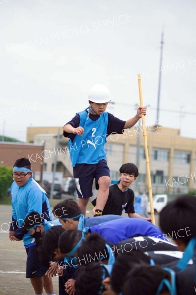仲間たちの背中を渡り続ける「川下り」競技。慎重かつ大胆に、バランスを保ちながら「船頭」も一気に駆ける（３１日、広尾、石原秀樹通信員撮影）