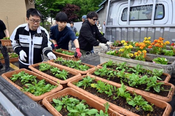 植えたプランターを運ぶ参加者ら