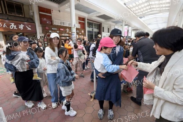 開会セレモニー後には先着１００人にお菓子セットをプレゼントする企画もあり、子どもたちが列を作った（助川かおる通信員撮影）