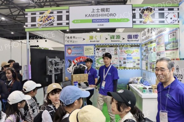 目を輝かせながら上士幌町のブースを訪れた上士幌小児童ら。右は竹中貢町長