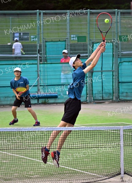 【男子個人戦ダブルス・２回戦】ハイボレーを試みる帯緑陽の中川旺亮（手前）。河村優亮との２年生ペアで全道１６強入りを遂げた