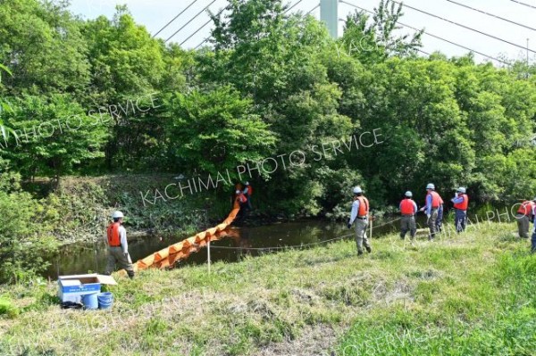 油流出を想定し、迅速にオイルフェンスを設置する参加者
