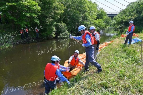 油流出を想定し、迅速にオイルフェンスを設置する参加者
