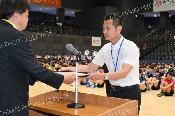 道高体連バレーボール専門部から表彰状を受け取る帯南商の鈴木和彦氏（右手前）＝金野和彦撮影