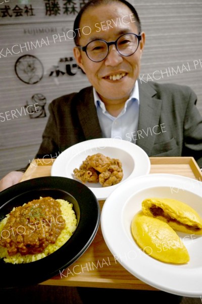 商品をＰＲする藤森商会の前谷さん（手前右から時計回りにインデアンまん、キーマカレー、スパイシーから揚げ）