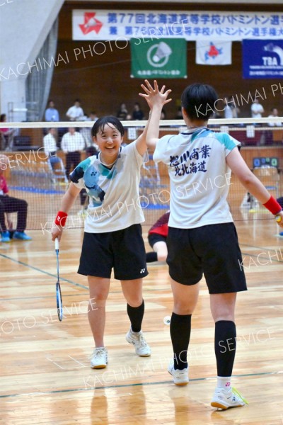 【女子団体戦北北海道決勝・旭川商―旭川実】第２ゲーム終盤、競り合いからポイントを奪い、タッチを交わす旭川商＝金野和彦撮影