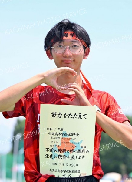 男子５０００メートル競歩で優勝し、表彰台でポーズを取る