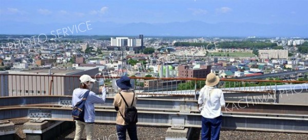 普段は立ち入ることができない帯広市役所屋上で日高山脈や市街地を眺める参加者（２５日午前９時４５分ごろ、塩原真撮影）