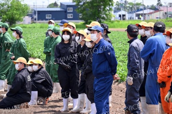 ドローンでの農薬散布を見学する生徒たち