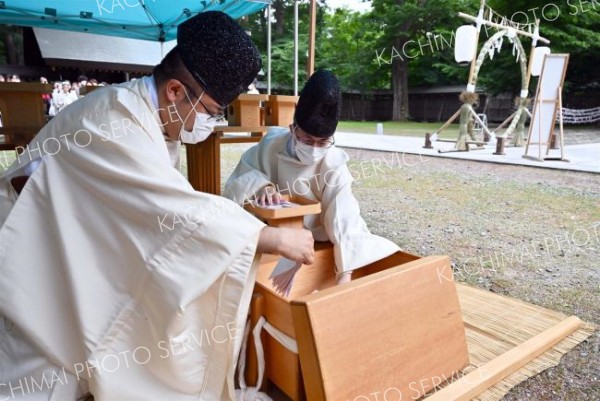 形代を木箱に収める神職（塩原真撮影）