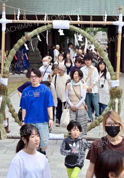 列をつくり茅の輪をくぐる参拝者（６月３０日、帯廣神社で。塩原真撮影）