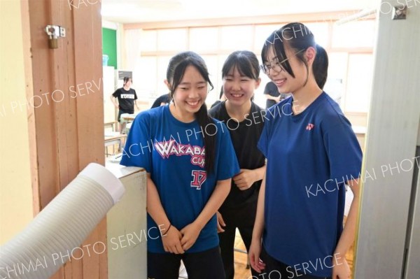 休み時間にスポットクーラーで涼む帯広第七中学校の生徒ら