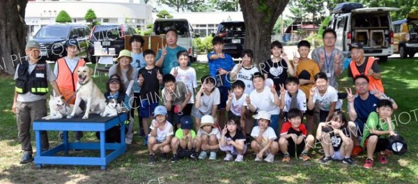 地域合同避難訓練に参加した児童と３頭の災害救助犬ら