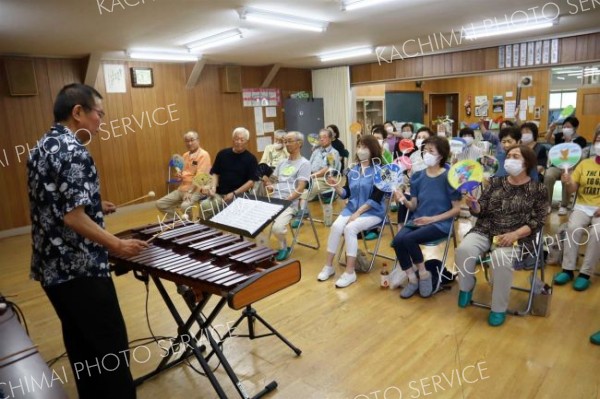 うちわを振りながら演奏を楽しむ参加者