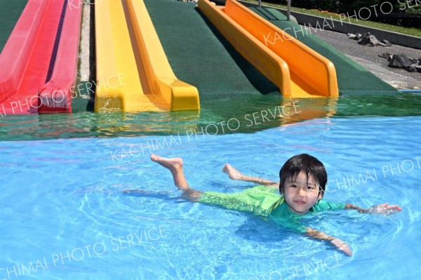 全身を水につけて暑さをしのぐ子ども（２４日午前１０時１５分ごろ、芽室公園で。須貝拓也撮影）