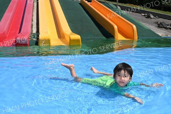 全身を水につけて暑さをしのぐ子ども（２４日午前１０時１５分ごろ、芽室公園で。須貝拓也撮影）