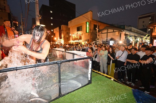 水しぶきを上げながらウナギをつかみ取る参加者（須貝拓也撮影）