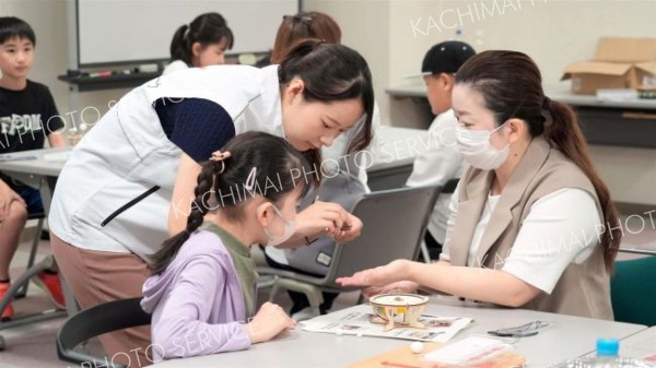 地球や太陽、月の動きを再現する天体模型の工作体験。ほくでんネットの社員に教えてもらいながら、小さな部品を組み合わせていった