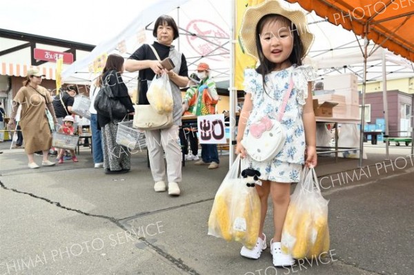 袋いっぱいのスイートコーンにうれしそうな子ども